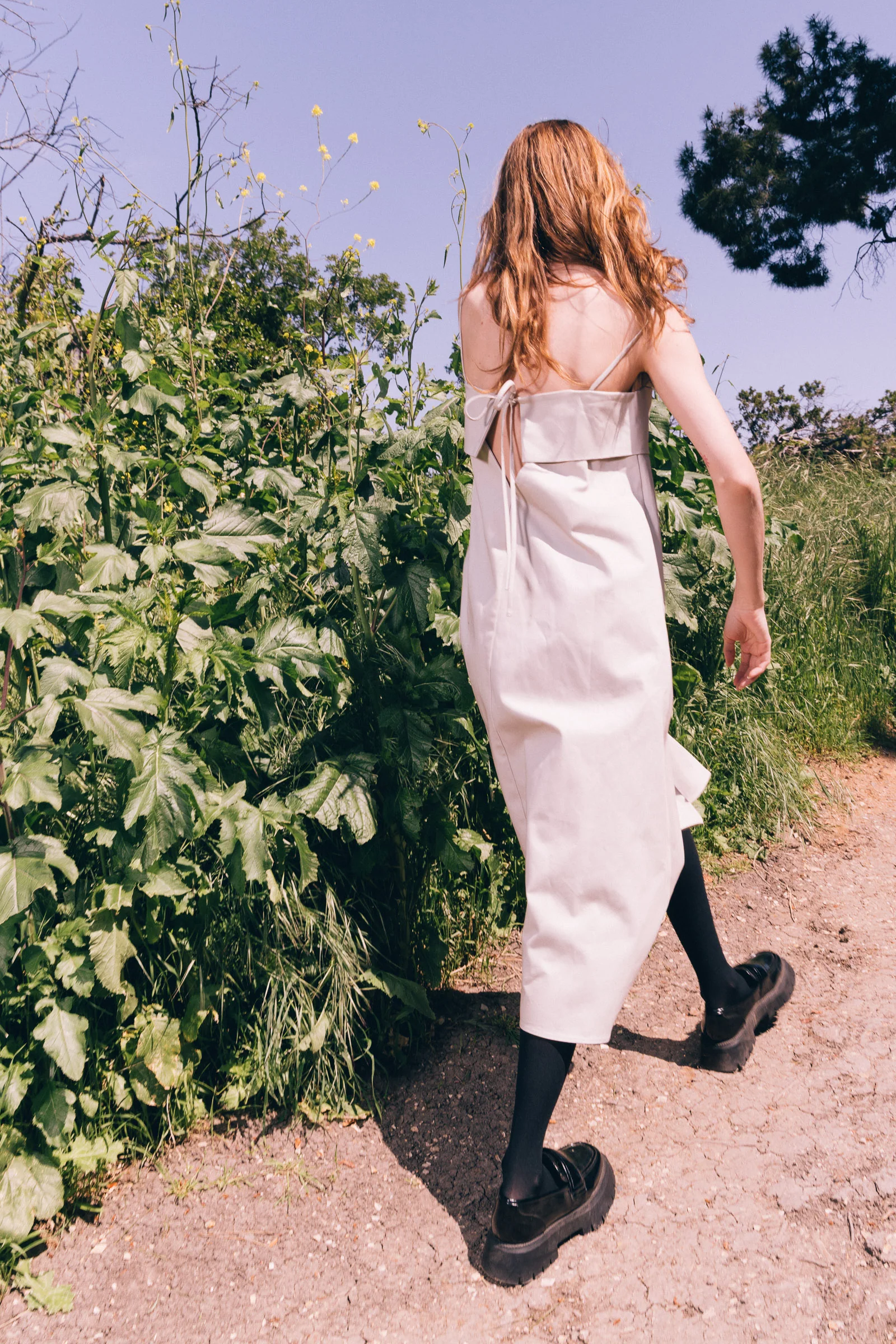 Model wearing a light dress walking outdoors